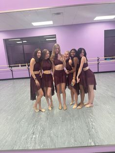 a group of women standing next to each other in front of a purple ball room