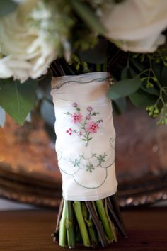 a vase filled with white flowers on top of a wooden table