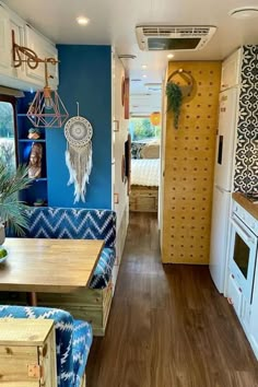 the interior of a camper with blue and yellow decor on the walls, wood flooring