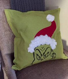 a green pillow with an image of dr seuss on it and a santa hat