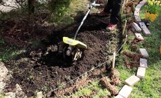 a man is digging in the ground with a wheelbarrow