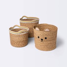 three woven baskets with cats faces on them