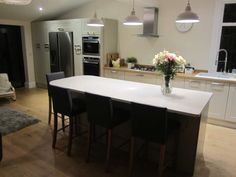 a kitchen with an island and chairs in it