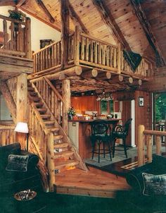 a living room filled with furniture next to a wooden staircase leading up to a loft