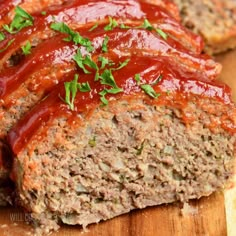 sliced meatloaf with ketchup and parsley on wooden cutting board, ready to be eaten