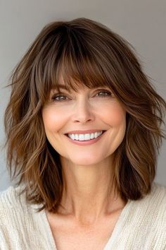 Save this pin for the best medium-length layered haircuts for women over 50. This tousled lob (long bob) brings together relaxed waves and soft layers. The bangs add a little something extra, giving it a fresh and modern touch. Layered Blonde Hair With Bangs, Lob Haircut With Bangs Over 50, Blow Dry Mid Length Hair, Layered Shoulder Length Haircut, Bangs Over 50 Medium Hair, 50 Year Old Hairstyles Medium Long Bobs, Medium Length Hair With Layers Over 50, Layered Hair Medium Straight, Medium Length Haircut With Layers Bangs