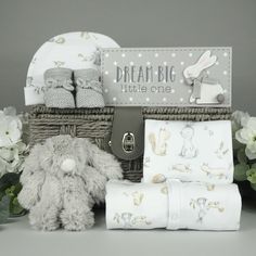 a baby gift basket filled with blankets and toys