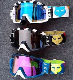 three snow goggles are lined up next to each other on a gray cloth background