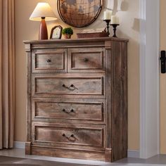 a wooden dresser sitting next to a lamp and a wall mounted globe on top of it