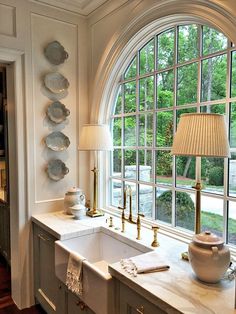 a kitchen with an arched window, sink and lamp in front of the countertop