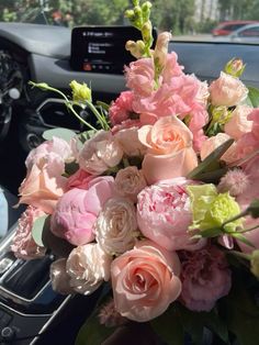 a bouquet of flowers sitting on the dashboard of a car