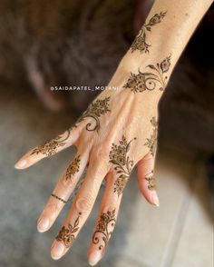 a woman's hand with henna tattoos on it