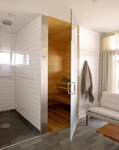 an open shower door in a bathroom next to a couch