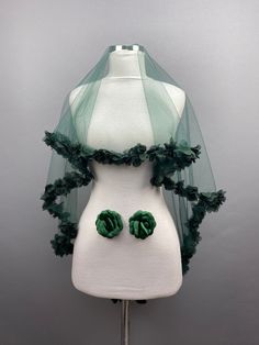 a white mannequin with green flowers on it's head and veil over its shoulders