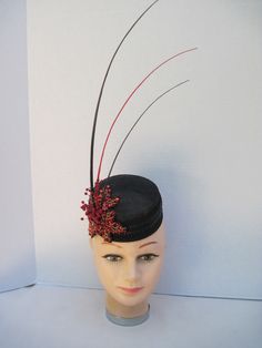 "* Designed on a black Sinamay pillbox hat form this hatinator will take you anywhere you want to go and will catch many eyes. The design includes a wide black leather braided trim complemented by handmade red sequen and bead worked Maple Leaves. To add a touch more of detail shiny red berries look good enough to eat. * The three black and red quills give dramatic height to the piece and upon ordering this is the exact fascinator you will receive. * With a hat diameter of 5.5\" it qualifies as f Black High Crown Fascinator For Kentucky Derby, Formal Black Mini Hat With High Crown, Black High Crown Top Hat For Races, Formal Black High Crown Mini Hat, Black High Crown Fascinator With Adjustable Fit, Black Short Brim Headpiece For Races, Black Adjustable Fascinator With Structured Crown, Black Structured Crown Top Hat For Kentucky Derby, Black Top Hat With Structured Crown For Kentucky Derby