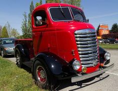 an old red truck parked in a parking lot