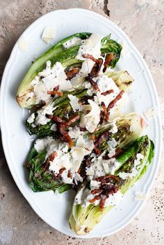 a white plate topped with brussel sprouts covered in feta cheese