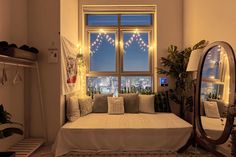 a room with a bed, mirror and lights on the window sill in it