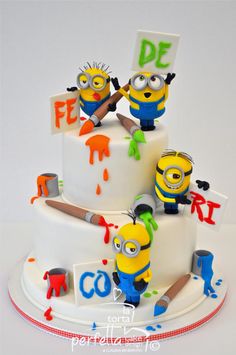 a three tiered cake decorated with minion characters and the words de ferro written on it