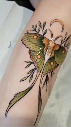 a small butterfly tattoo on the arm with flowers and leaves around it's wings