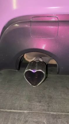 the trunk of a purple car with a heart shaped exhaust pipe sticking out of it