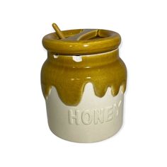 a ceramic honey jar with a wooden lid