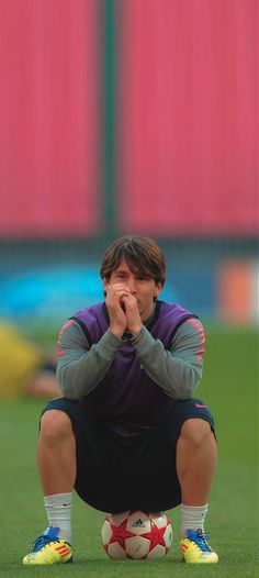 a man kneeling down on top of a soccer field holding his hands to his face