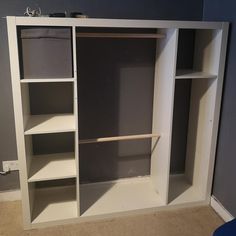 an empty closet with no doors and shelves on the wall, is being painted white