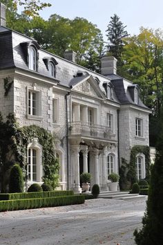 a large white house surrounded by trees and bushes