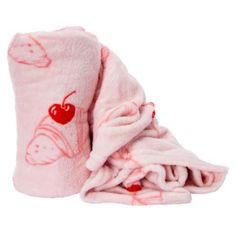 a pink blanket with cherries on it is folded up to show the bottom and side