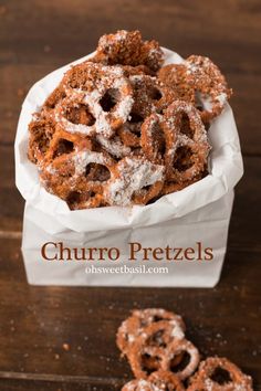 churro pretzels with powdered sugar on top in a white paper container