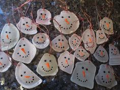 snowman ornaments are hanging from string on the counter