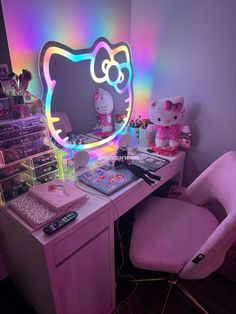 a desk with a hello kitty light up mirror on it's side and a pink chair in front of it