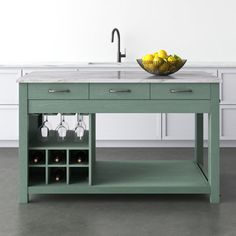 a green kitchen island with wine glasses on it