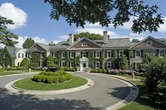 a large house with lots of windows and bushes around it's front lawn area