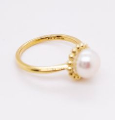 This lovely cultured pearl ring is the perfect gift for a loved one or a great self purchase. The nice size pearl has a gold beading design that is very simple but elegant. The pearl is the most desirable color with a nice white color with rose hues. This ring is a size 6.5 but is sizable. Just let our shop know what size your need and our in house jeweler can take care of that. The details for this beautiful ring are listed below:Metal Quality: 14 K Yellow Gold Gemstone: Freshwater Pearl Gemsto Classic Round Pearl Ring With Pearl Drop, Classic Pearl Ring With Pearl Drop, Pearl Rings With Pearl Chain For Gift, White Gold Pearl Ring With Pearl Drop, Pearl Ring With Pearl Chain As A Gift, White Pearl Ring With Pearl Chain, Gift Pearl Ring With Pearl Chain Detail, Pearl Chain Ring Perfect As A Gift, Classic White Pearl Ring With Pearl Charm