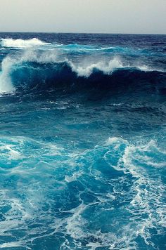 two surfers are riding the waves on their surfboards in the ocean with blue water