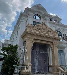 a large white building with a clock on it's side and scaffolding