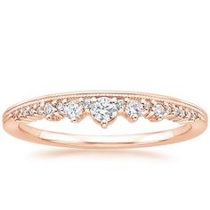 a yellow gold wedding band with three heart shaped diamonds