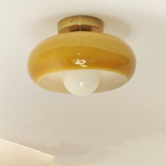 a light that is hanging from the ceiling in a room with white walls and flooring