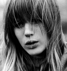 a black and white photo of a woman with long hair, wearing a turtle neck sweater