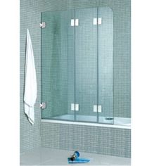 a glass shower door in a bathroom with white towels on the floor and blue towel next to it