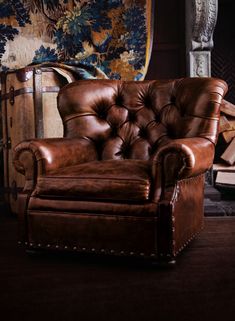 a brown leather chair sitting in front of a fireplace