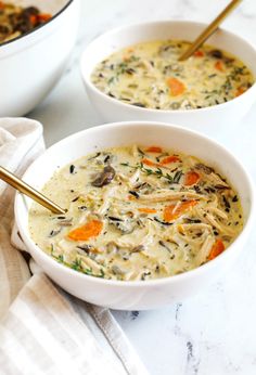 two white bowls filled with soup on top of a table