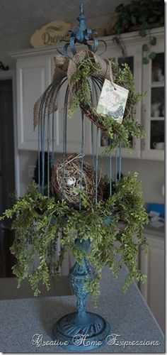 a bird's nest is sitting on top of a blue vase filled with greenery