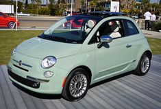 a small green car parked in front of a building