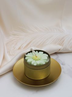 a white flower in a gold plate on a marble surface