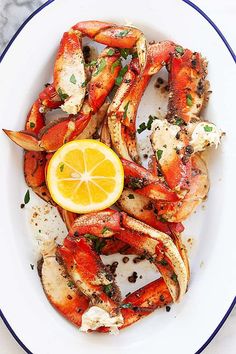 crab legs with lemon wedges on a white plate