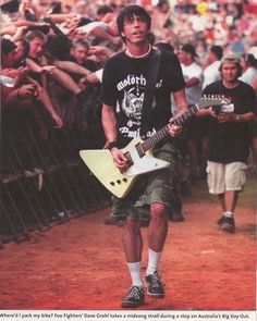 a man with a guitar walking in front of a crowd