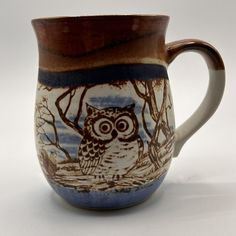 a coffee cup with an owl painted on the outside and inside, sitting in front of a white background